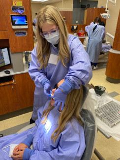 2 Blonde PEPP-DMD Students in the Dental Clinic wearing PPE.