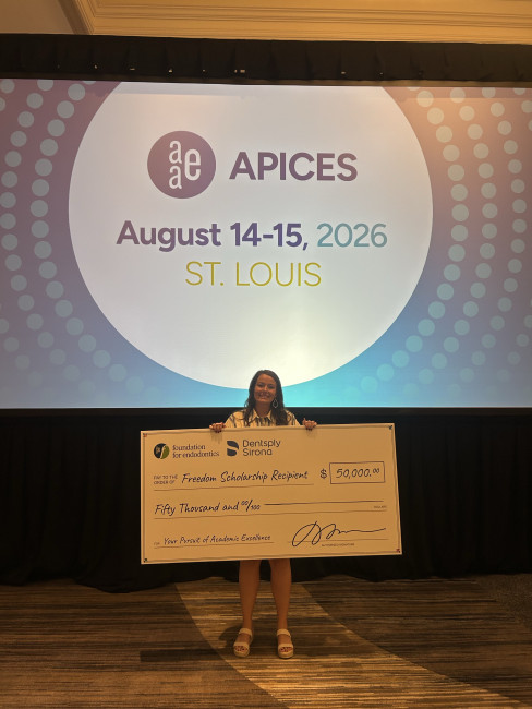 Dr. Sierra Nunn holds oversized check worth $50,000.