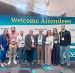 Endodontics faculty and students standing in front of a "Welcime Attendees" sign.