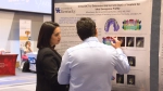 Student and Faculty member looking at research poster