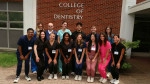 Students in scrubs in front of the College of Dentistry.