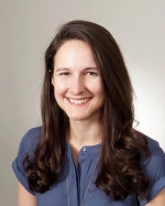 Dr. Emily Winfrey. She has long brown hair and is wearing a blue blouse with short sleeves